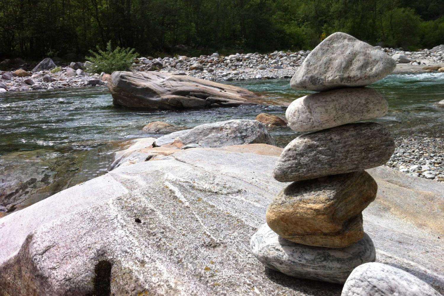 Die aufeinander gelegten Steine am Ufer eines Bergbaches symbolisieren 